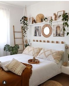 a bedroom with white walls and plants on the wall