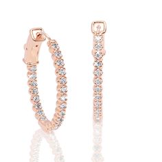 a pair of rose gold hoop earrings with clear stones