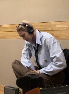 a man wearing headphones sitting on top of luggage