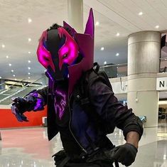 a person wearing a purple mask and black gloves