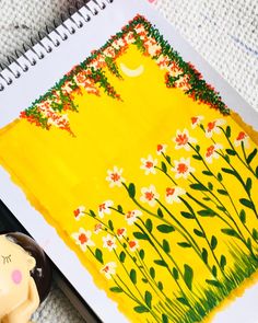 a drawing of flowers on a yellow background next to a toy elephant and pencils