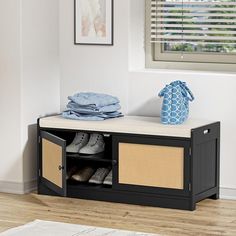 a shoe rack with shoes and clothes on it in front of a window, next to a rug