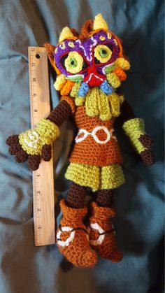 a crocheted stuffed animal is next to a ruler