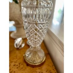 a clear glass vase sitting on top of a counter next to a window sill