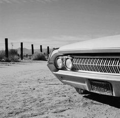 an old car is parked in the desert