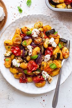 a white plate topped with roasted vegetables and feta cheese