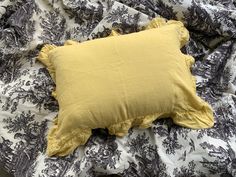 a yellow pillow sitting on top of a bed