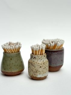 three ceramic vases with toothpicks in them