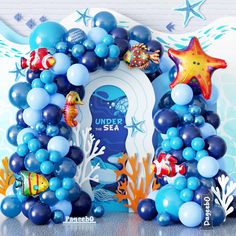 an under the sea balloon arch with blue and white balloons