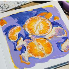 an orange is cut in half and placed on a piece of paper with colored pencils next to it