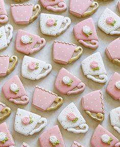 pink and white cookies decorated like tea cups, saucers, and purses on a table