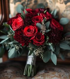 a bouquet of red flowers sitting on top of a chair