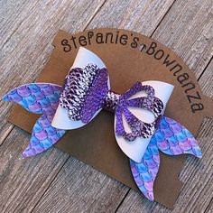 a purple and white hair bow on top of a piece of cardboard with the words steffaanie's brown ribbon