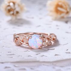 an opal and diamond ring sits on a lace doily