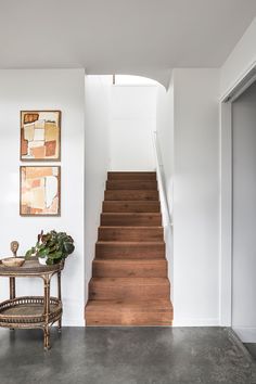 there is a chair and table in the room next to the stairs that lead up to the second floor