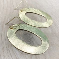 "These handcrafted earrings are modern and chic! Large gold circular hoops measuring over 2 inches long by 1.5 inches wide dangle from matching fish hooks. Earring material is brass dipped in brushed gold and lacquered with a protective varnish to prevent tarnish. Such beautiful texture! The earrings measure approximately 2.75\" in total length. A fabulous chunky look in a super lightweight style! Item is carefully packaged and shipped via USPS in a sturdy protective mailer. Check out more fabul Chic Handmade Gold Earrings, Chic Gold Handmade Earrings, Chic Hammered Metal Earrings, Handmade Gold Oval Hoop Earrings, Handmade Oval Gold Hoop Earrings, Modern Brass Hoop Earrings For Party, Minimalist Brass Hoop Earrings For Party, Modern Handmade Gold Linear Earrings, Modern Gold Hoop Linear Earrings