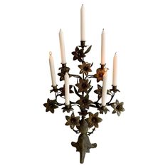 an iron candelabra with five candles in the shape of flowers and leaves