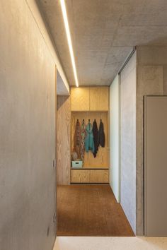 an empty hallway with coats hanging on the wall