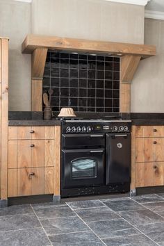 a black stove top oven sitting inside of a kitchen next to wooden cupboards and counter tops