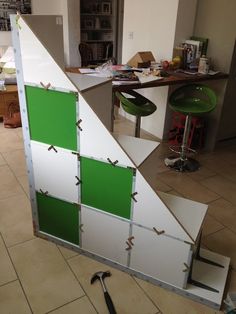 a green and white piece of furniture in the middle of a room with tile flooring