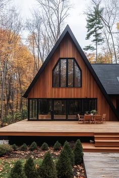 a large wooden house surrounded by trees in the fall