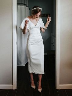 a woman in a white dress is taking a selfie