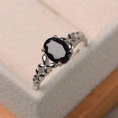 a black diamond ring sitting on top of a white box