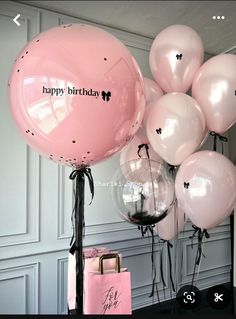 a bunch of balloons that say happy birthday and are in front of a pink bag