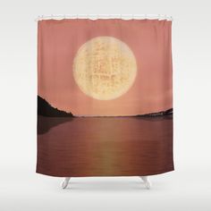 a shower curtain with an image of the moon over water