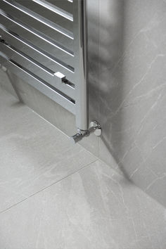 an image of a stainless steel radiator on the wall in a bathroom setting