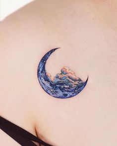 a woman's stomach with a tattoo on it that looks like a crescent moon