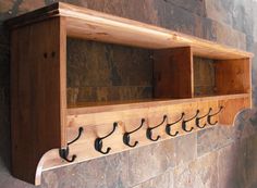 a wooden shelf with several hooks on it