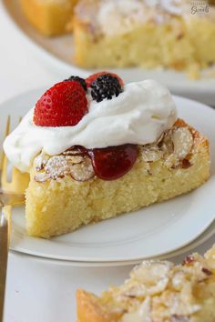 a piece of cake with whipped cream and fruit on top is sitting on a plate