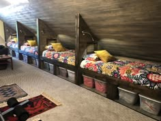 bunk beds are lined up against the wall with storage baskets on each bed and underneath them