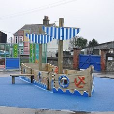 a children's play area in the middle of an empty lot with blue tarps