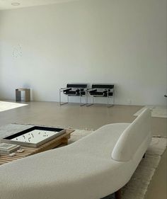 a living room filled with furniture and large windows next to a white flooring area