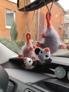 three stuffed animals hanging from the dashboard of a car