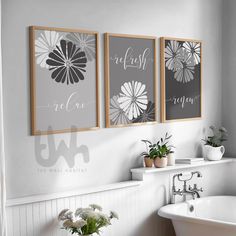 three framed art prints on the wall above a bathtub