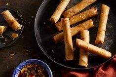 several different types of food on a plate next to bowls and plates with sauces