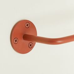 a close up of a red handle on a white wall with four holes in it