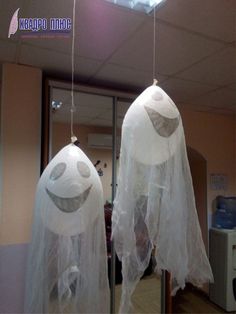 two plastic ghost heads hanging from the ceiling