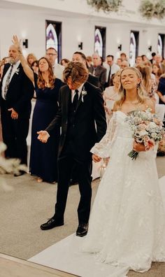 a bride and groom walking down the aisle