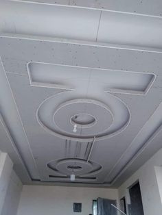 the ceiling in an office building is painted white and has round holes on it, as well as circular lights