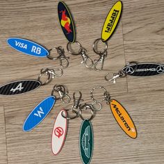 a bunch of key chains that are on top of a wooden floor with different colors