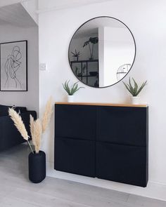 a living room with a black cabinet and mirror