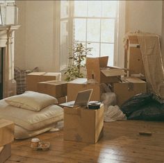 a living room filled with lots of boxes on the floor next to a fire place