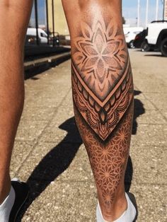 a man's leg with an intricate tattoo design on the lower part of his leg