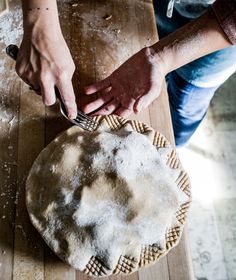 an image of someone cutting something on a wooden table with a knife and fork in it