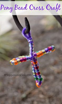 a cross made out of beads hanging from a metal pole with text overlay saying how to make a pony bead cross craft