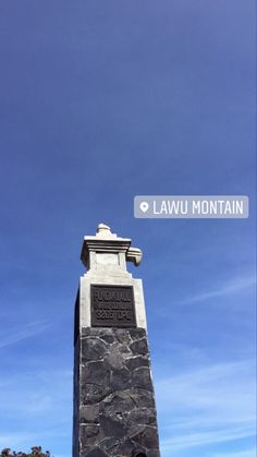 there is a monument in front of the lawu mountain sign on this sunny day